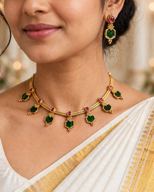 Close-up of emerald green and ruby stone jhumka earrings