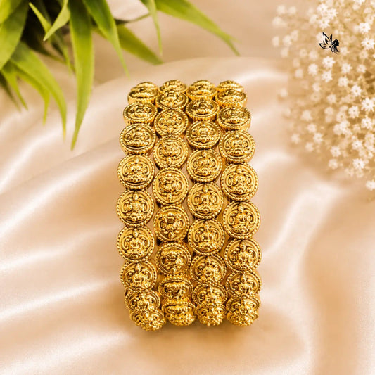 Gold bracelet with intricate design on a beige fabric background