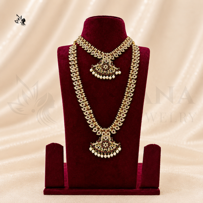 An ornate gold and white Kundan necklace set displayed on a deep red velvet jewelry bust against a beige satin fabric background.